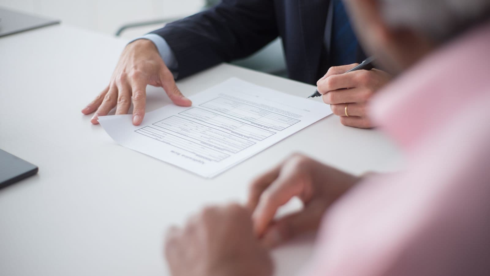 Deux professionnels signant des documents lors d'un rendez-vous d'affaires, illustration de la création d'une société en Belgique