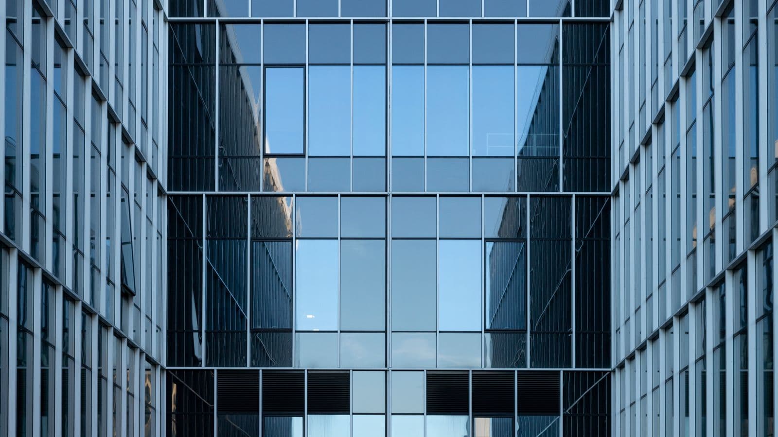 Façade vitrée contemporaine d'un immeuble de bureaux, illustrant une adresse de siège social pour la domiciliation d'entreprise à Courtrai