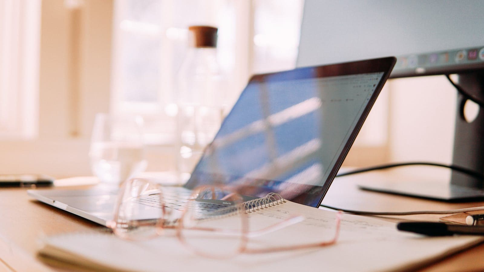 Bureau à domicile avec ordinateur portable et lunettes près d'une fenêtre