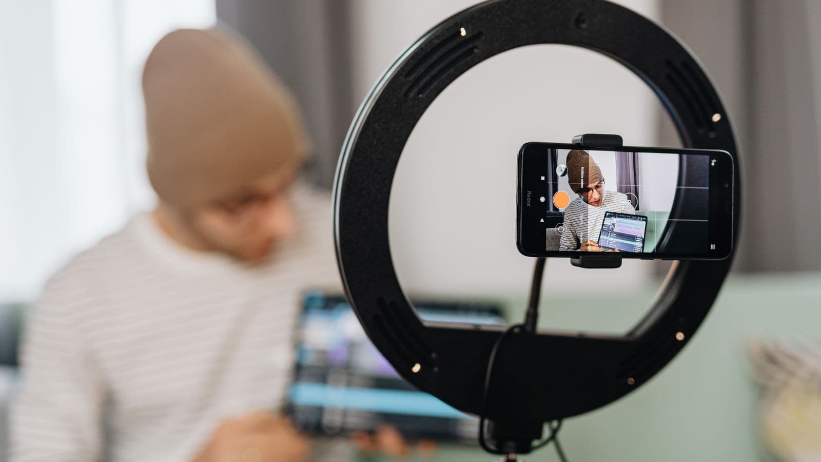 Créateur de contenu filmant une vidéo face caméra dans un studio à domicile en Belgique