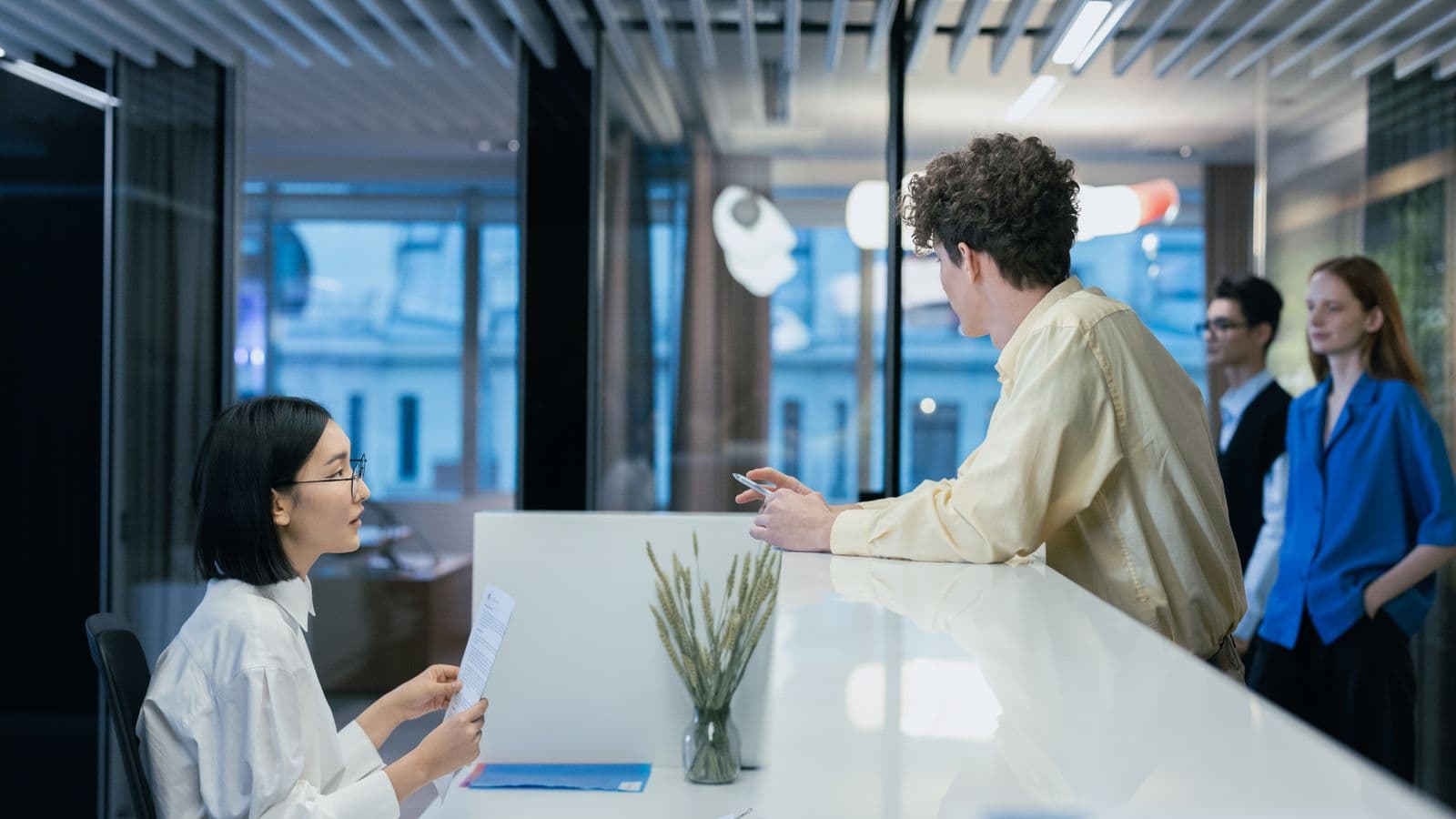 Un entrepreneur dépose un dossier au comptoir d'accueil d'un bureau moderne