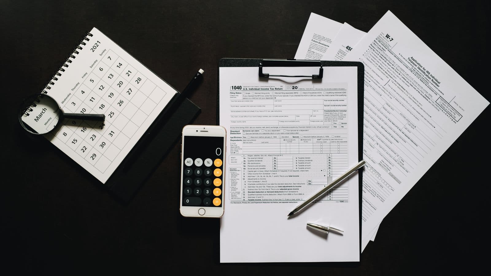 Documents fiscaux, calculatrice et formulaires sur un bureau, illustration des incitants fiscaux pour une société en Belgique