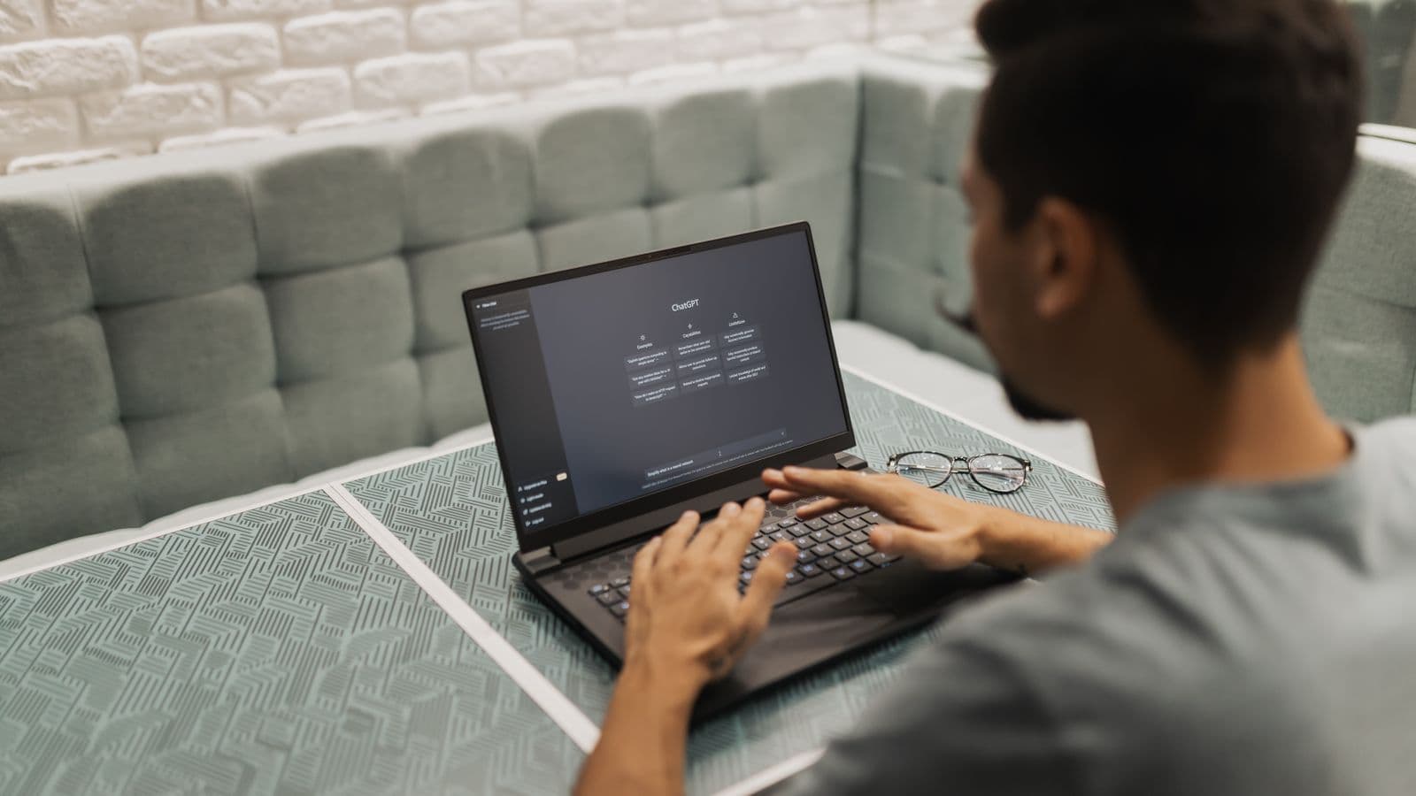 Indépendant travaillant sur un ordinateur portable avec un assistant d'intelligence artificielle dans un petit bureau
