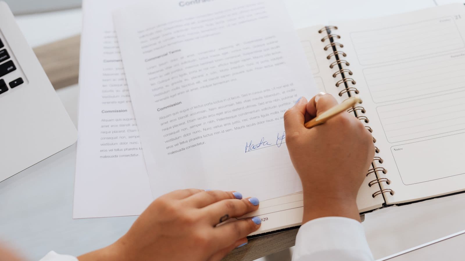 Signature d'un acte notarié sur un bureau avec des documents et fournitures de bureau