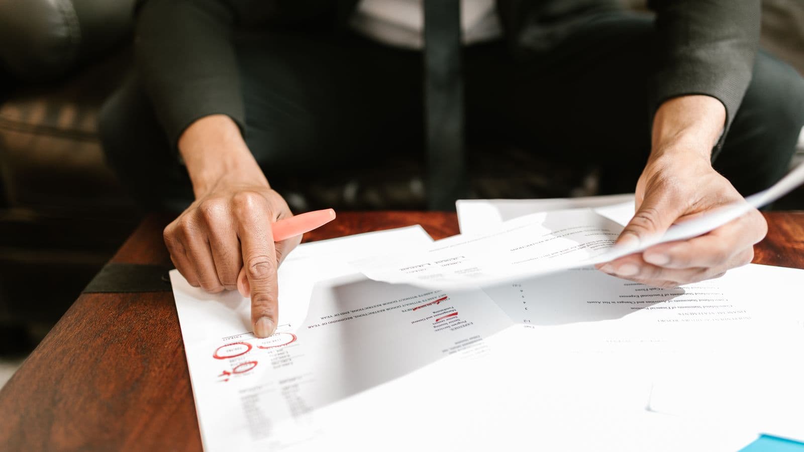 Gérant analysant des documents financiers avec des données chiffrées sur son bureau