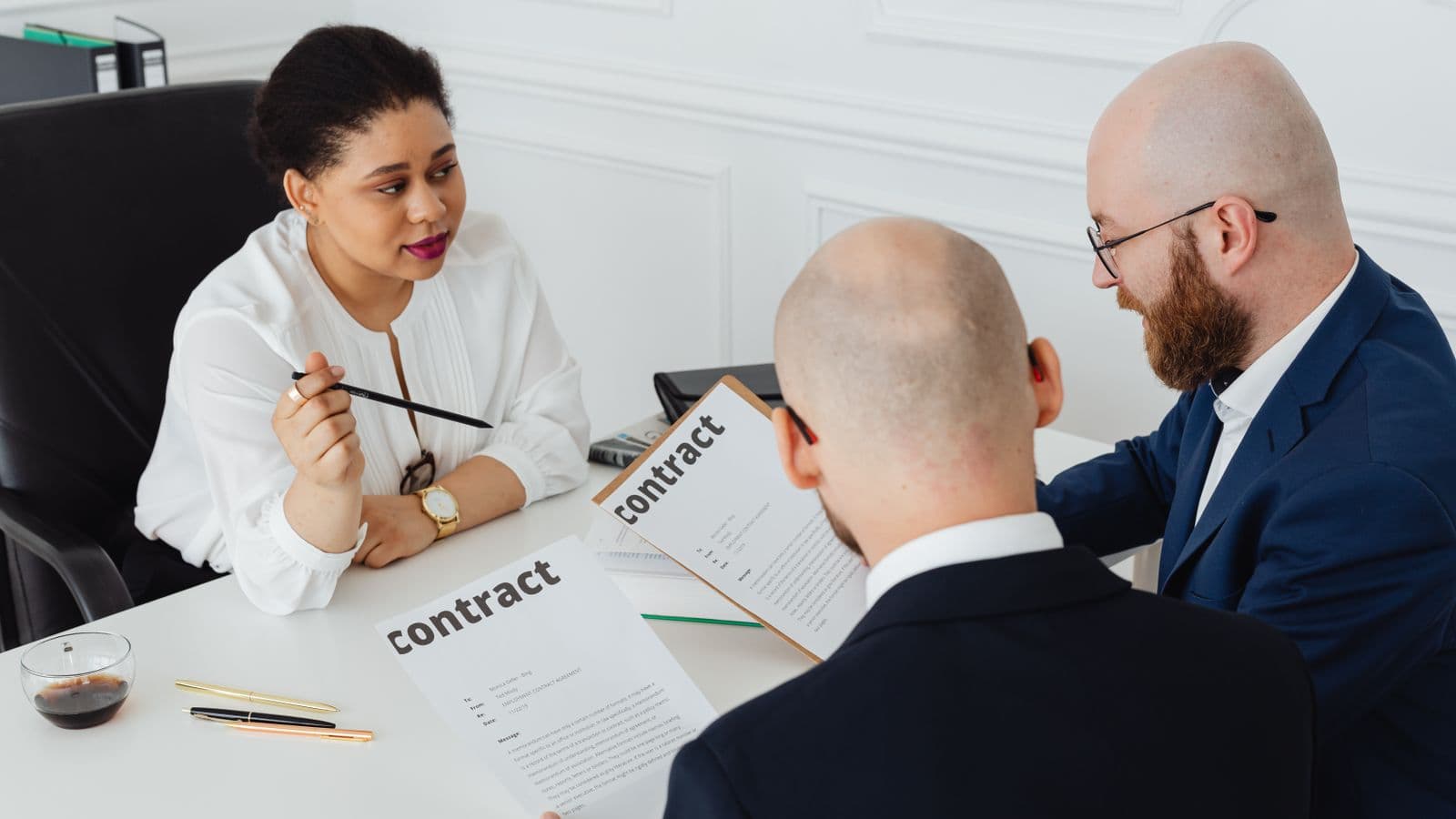 Trois professionnels examinant ensemble un document de procuration lors d'une réunion