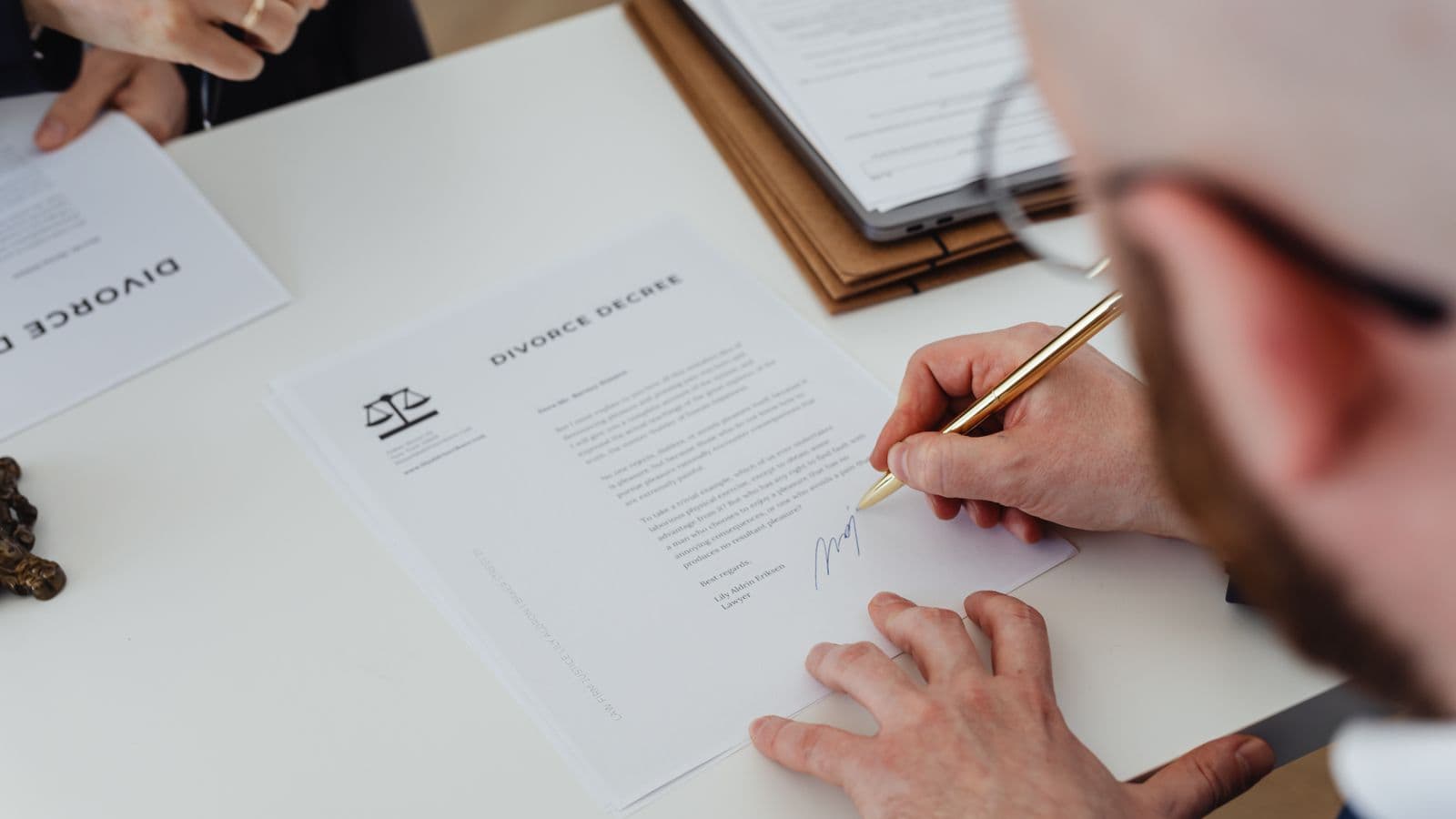 Personne signant des documents officiels sur un bureau, illustration de la publication d'une ASBL au Moniteur belge