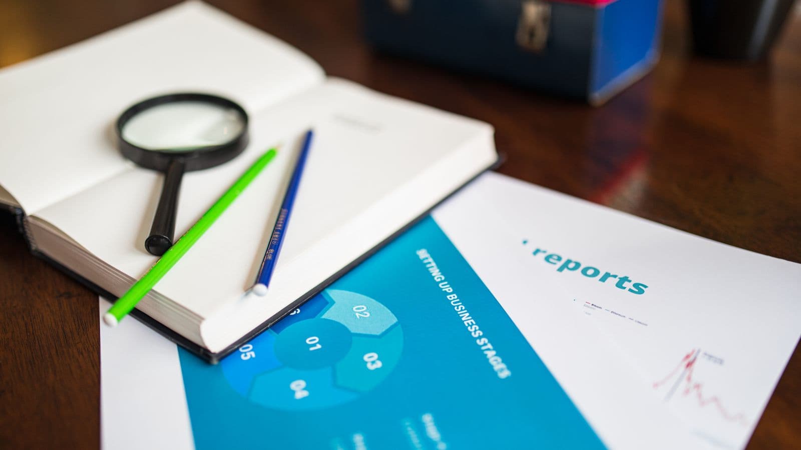 Registre ouvert avec loupe et documents d'entreprise sur un bureau en bois