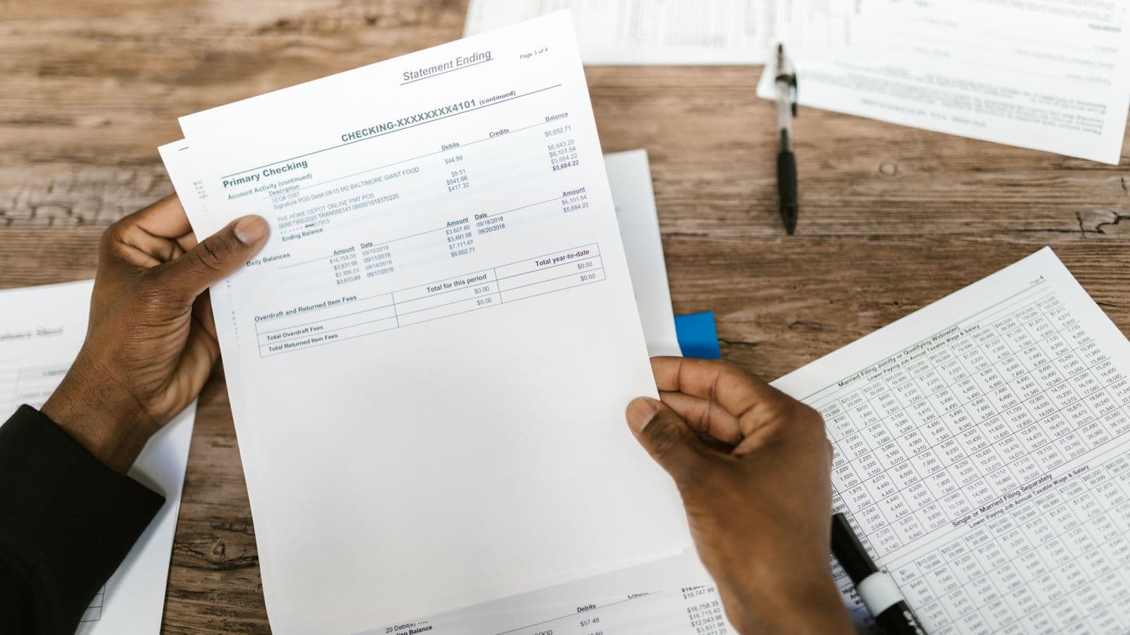 Mains tenant des documents comptables et financiers pour une analyse fiscale