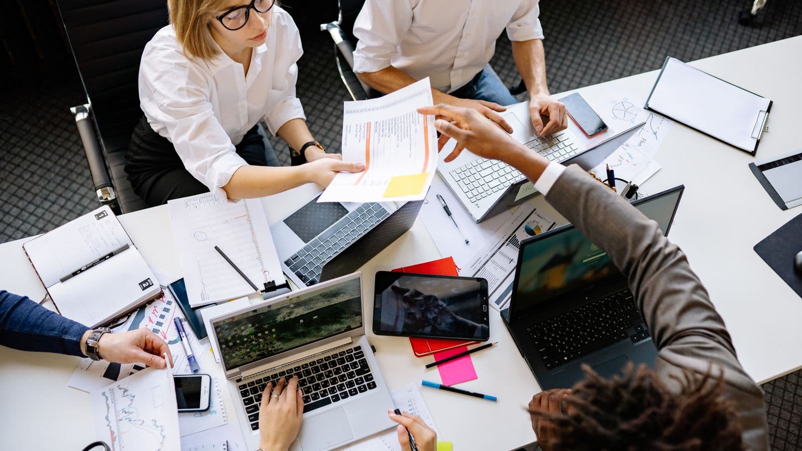 Équipe diversifiée travaillant sur des ordinateurs portables dans un bureau moderne, illustration de la création d'une startup en Belgique