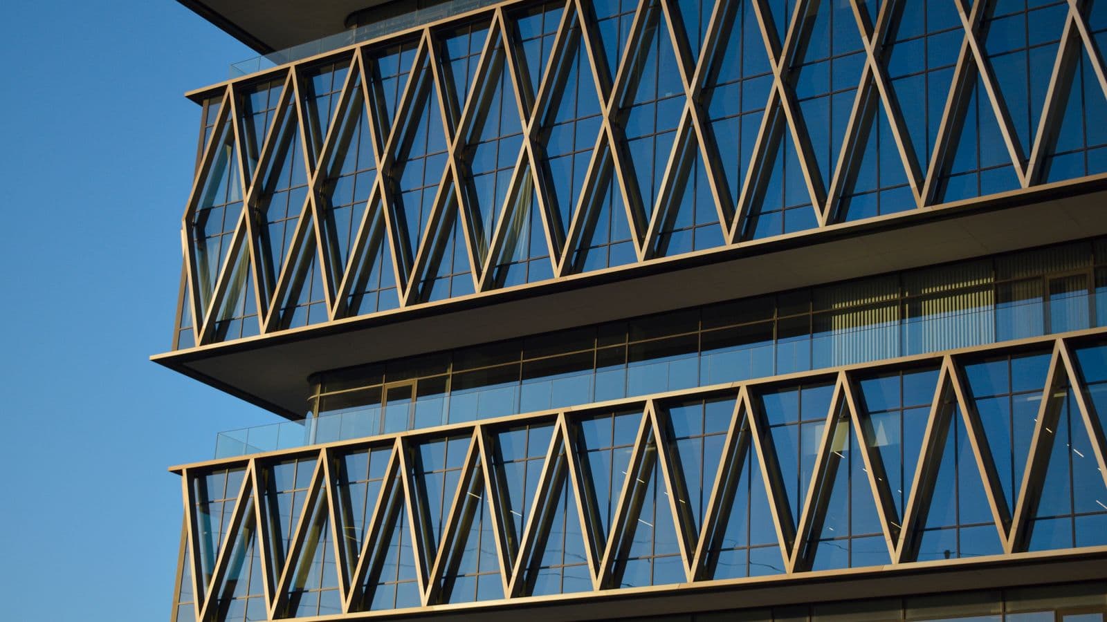 Façade moderne d'un immeuble de bureaux à structure vitrée, illustrant une adresse de siège social pour la domiciliation d'entreprise à Hasselt