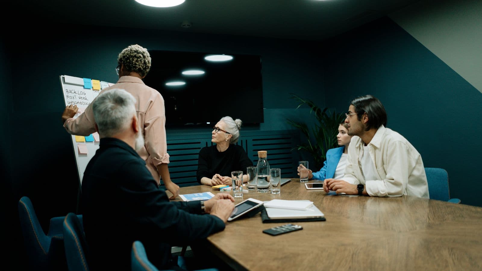 Équipe de professionnels en réunion de direction dans une salle de conférence moderne