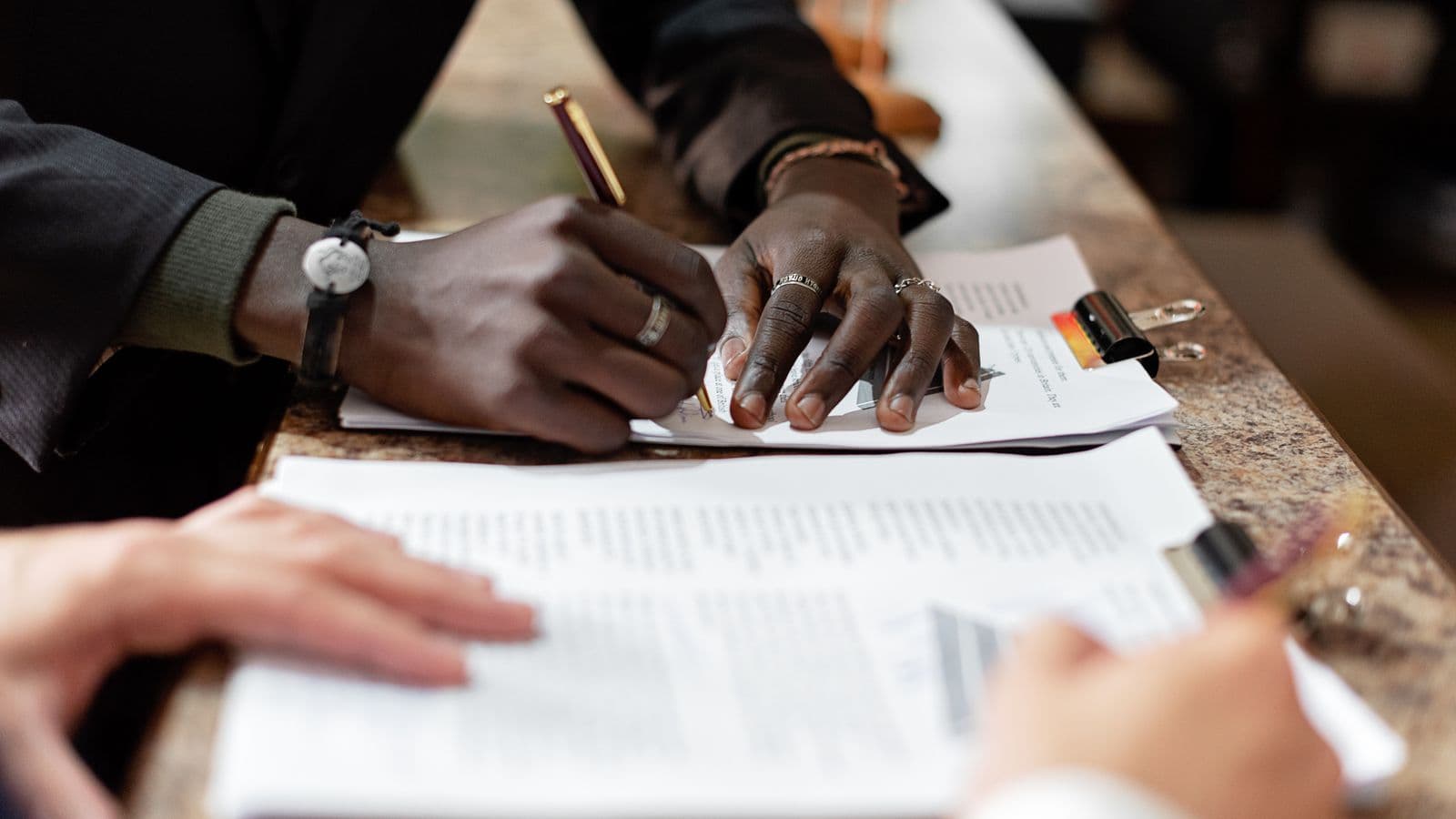 Mains signant un document de convention d'actionnaires dans un cadre professionnel
