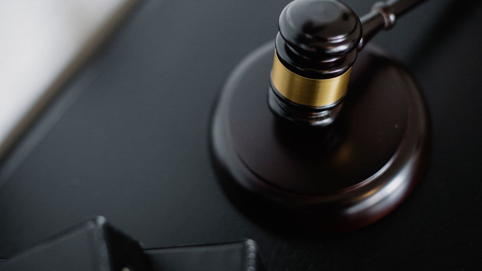 Marteau de juge sur une table de tribunal avec des dossiers, symbolisant la procédure de réorganisation judiciaire en Belgique